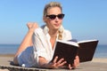 Woman reads a book on the beach Royalty Free Stock Photo