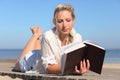 Woman reads a book on the beach Royalty Free Stock Photo