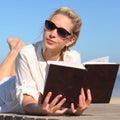 Woman reads a book on the beach Royalty Free Stock Photo