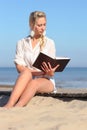 Woman reads a book on the beach Royalty Free Stock Photo