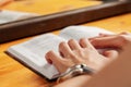 A woman reads a book before going to bed. Women`s hands are holding a book in close-up. An open paper book is lying on the table Royalty Free Stock Photo