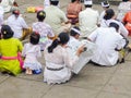 Woman reads newpaper while participating on a religious ceremony