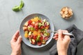 Woman ready to eat Panzanella Italian salad with tomatoes, cheese and crispy croutons.