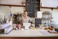 Woman ready to serve behind the counter at a coffee shop Royalty Free Stock Photo