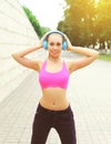 Woman ready to workout in city, female athlete with headphones listens to music, sport and healthy lifestyle