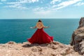 A woman, rear view in a red flying dress fluttering in the wind, a girl in a fluttering dress on the background of the Royalty Free Stock Photo