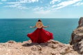 A woman, rear view in a red flying dress fluttering in the wind, a girl in a fluttering dress on the background of the Royalty Free Stock Photo