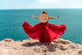 A woman, rear view in a red flying dress fluttering in the wind, a girl in a fluttering dress on the background of the Royalty Free Stock Photo