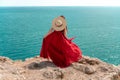 A woman, rear view in a red flying dress fluttering in the wind, a girl in a fluttering dress on the background of the Royalty Free Stock Photo