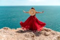 A woman, rear view in a red flying dress fluttering in the wind, a girl in a fluttering dress on the background of the Royalty Free Stock Photo