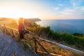 Woman rear view watching sunset landscape Conero natural park dramatic coast headland rocky cliff adriatic sea beautiful sky Royalty Free Stock Photo