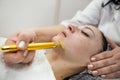 woman receive procedure procedure on face with golden pulse facial massager