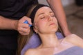 Woman receives facial cupping massage facial rejuvenation at acupuncture wellness spa.