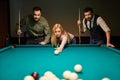 young caucasian woman receiving advice on shooting pool ball while playing billiards with friends Royalty Free Stock Photo
