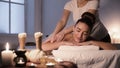 Woman receiving back massage, enjoying evening in spa