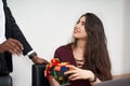 Woman receiving a beautiful gift from her male colleague while working in the office, relationships concept Royalty Free Stock Photo