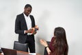 Woman receiving a beautiful gift from her male colleague while working in the office, relationships concept Royalty Free Stock Photo