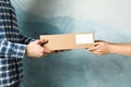 Woman receiving boxes from delivery man against blue background Royalty Free Stock Photo