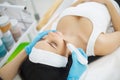 Woman receiving electric facial peeling at european beauty salon.