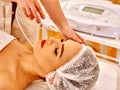 Woman receiving electric facial peeling massage.