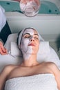 Woman receiving facial mask from beautician in spa Royalty Free Stock Photo