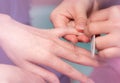 Woman receiving fingernail manicure service by professional manicurist at nail salon. Beautician file nail manicure at nail Royalty Free Stock Photo