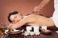 Woman receiving hot stone therapy in spa Royalty Free Stock Photo