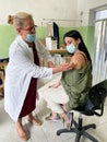 Woman receiving an injection in her arm.