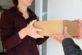Woman Receiving A Package From A Currier
