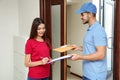 Woman receiving padded envelope from delivery service courier