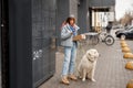 Woman receiving a parcel from automatic post machine during a walk with her dog Royalty Free Stock Photo