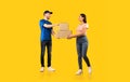 Woman Receiving Parcel Boxes From Courier Standing Over Yellow Background