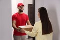 Woman receiving parcel from courier at home Royalty Free Stock Photo