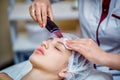 Woman receiving ultrasonic facial exfoliation at cosmetology salon. Royalty Free Stock Photo