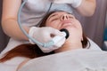 Woman at the reception at the beautician during spa procedures. Radio frequency procedure. Non-surgical facial skin rejuvenation Royalty Free Stock Photo