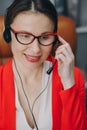 Woman receptionist wear headset consulting customer looking at computer talking with client in online computer chat Royalty Free Stock Photo