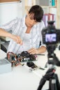 woman recording electronics tutorial with camera on tripod