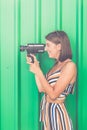 Woman recording. Side portrait of young person capturing video with retro film camera. Royalty Free Stock Photo