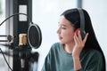 A woman is recording a song in a studio