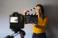 Woman recording a video and holding a movie clapboard