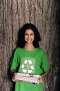 Woman with recycling sign holding newspapers