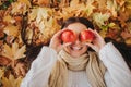 Woman with red apple in autumn park. Season, fruit and people concept - beautiful girl lying on ground and autumn leaves Royalty Free Stock Photo