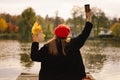 Woman in a red beret reading book on wooden pontoon. Autumn season. Royalty Free Stock Photo