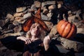 Woman with red blood and with blond hair. Scary bloody girl in wizard orange hat with pumpkin. Halloween party art