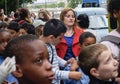 Woman in red and blue surrounded by group of young people