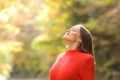 Woman in red breathing fresh air in autumn in a forest Royalty Free Stock Photo