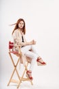 Woman on a red chair in a bright room and sandals jacket