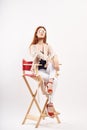 Woman on a red chair in a bright room and sandals jacket model