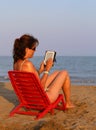 Woman on red chair reads the ebook Royalty Free Stock Photo