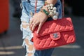 Woman with red Chanel bag and big pearls bracelet before Stella Jean fashion show, Milan Fashion Week street